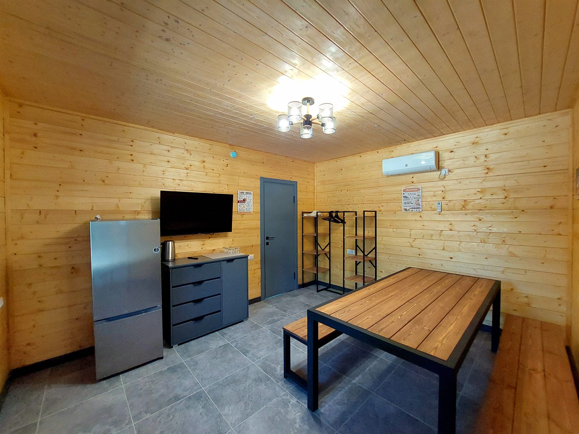 Комната отдыха при бане с длинным столом и телевизором
